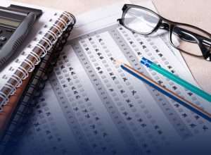 Scantron answer sheets, pencils, calculator, and glasses representing tools students use while managing exam anxiety and preparing for tests.